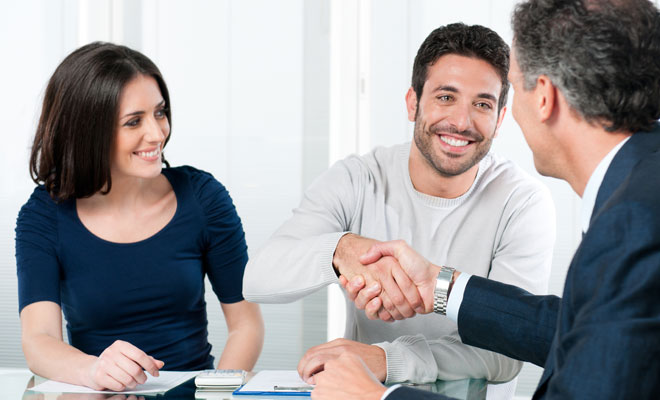 Financial representative talking to a young couple.