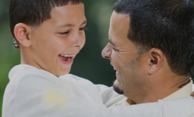 Father and son smiling at each other and having a great time.