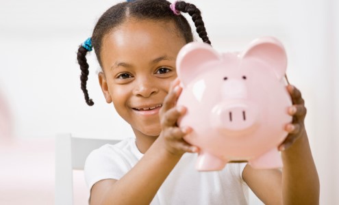 Small girl with a piggy bank.