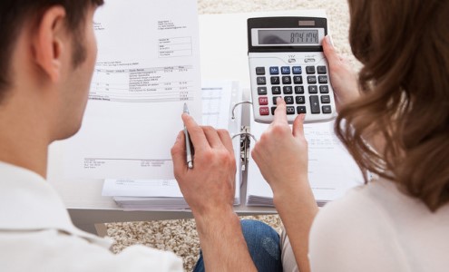 Man and woman working on finances with calculator