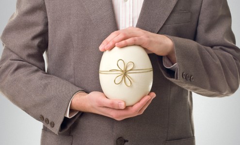 man holing decorative egg in his hands.