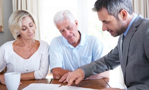 Financial representative having discussion with an elderly couple.