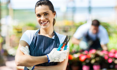 Young woman working at the plant nursery.