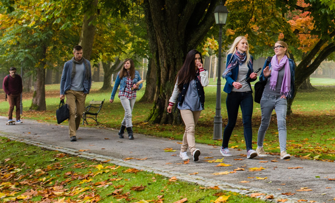 Students walking on the college campus on a beautiful fall day.